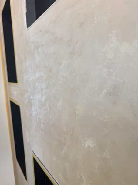 Kreativtechnik – Detail Detail einer dekorativen Wandoberfläche in hellen Beigetönen mit schimmernder Struktur.